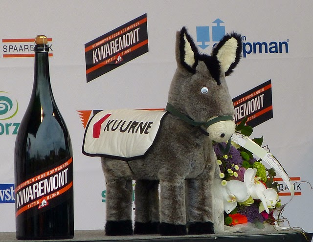 Premiação da prova em Kuurne, uma cerveja, um burro de pelúcia e um buquê de flores