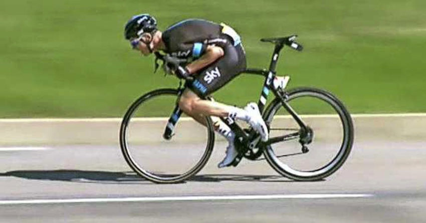 Chris Froome sentado no tubo da bicicleta em descida de alta velocidade